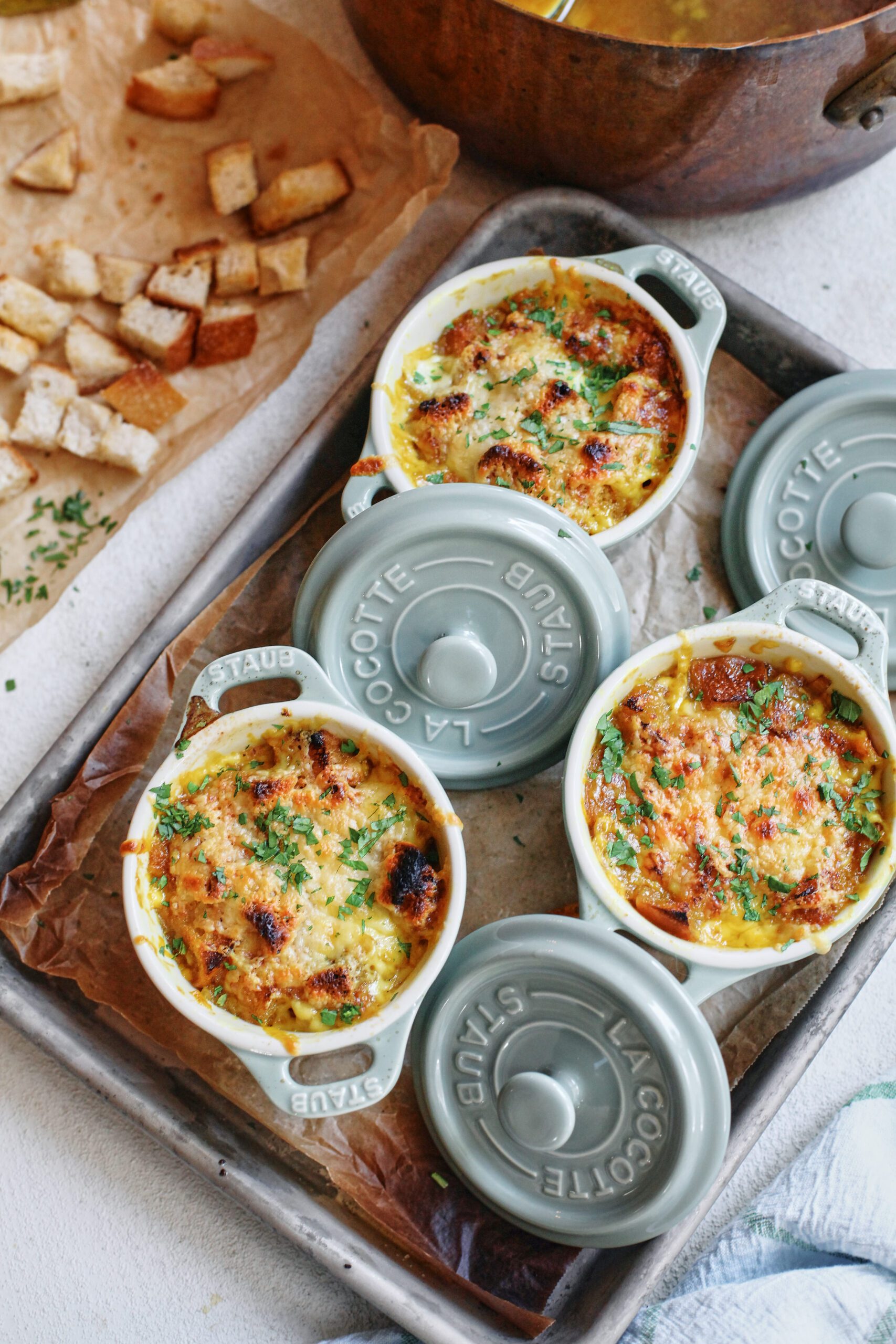 crocks of golden garlic soup after being broiled