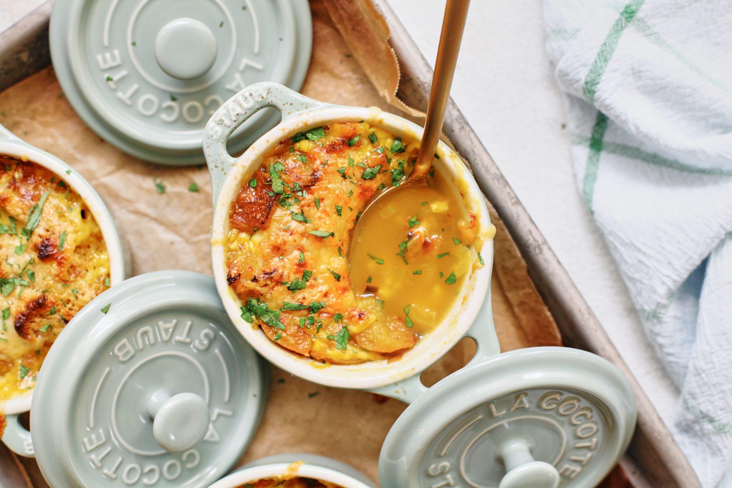 crocks of golden garlic soup after being broiled