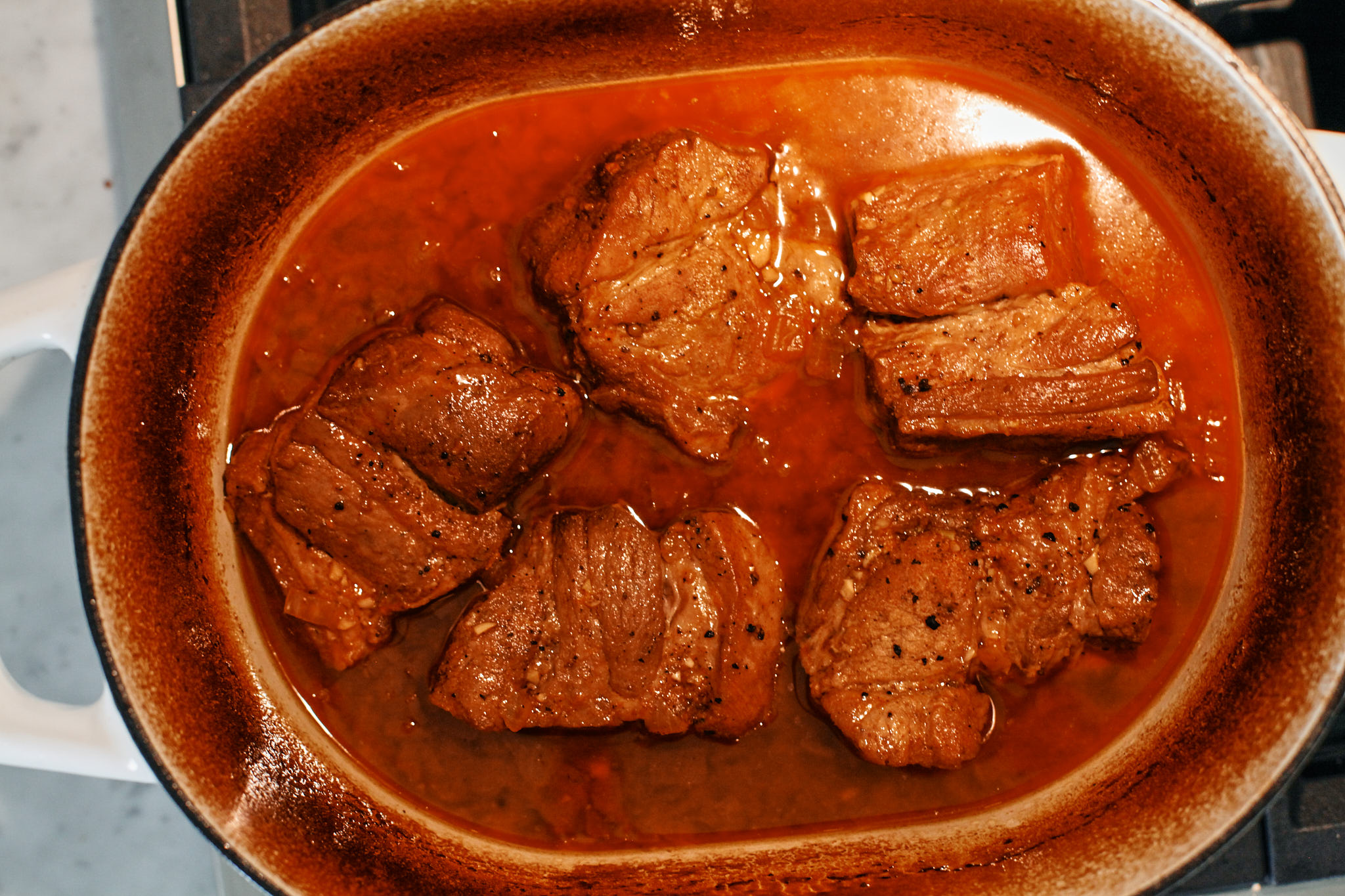 braised citrus pork with the sauce in the dutch oven