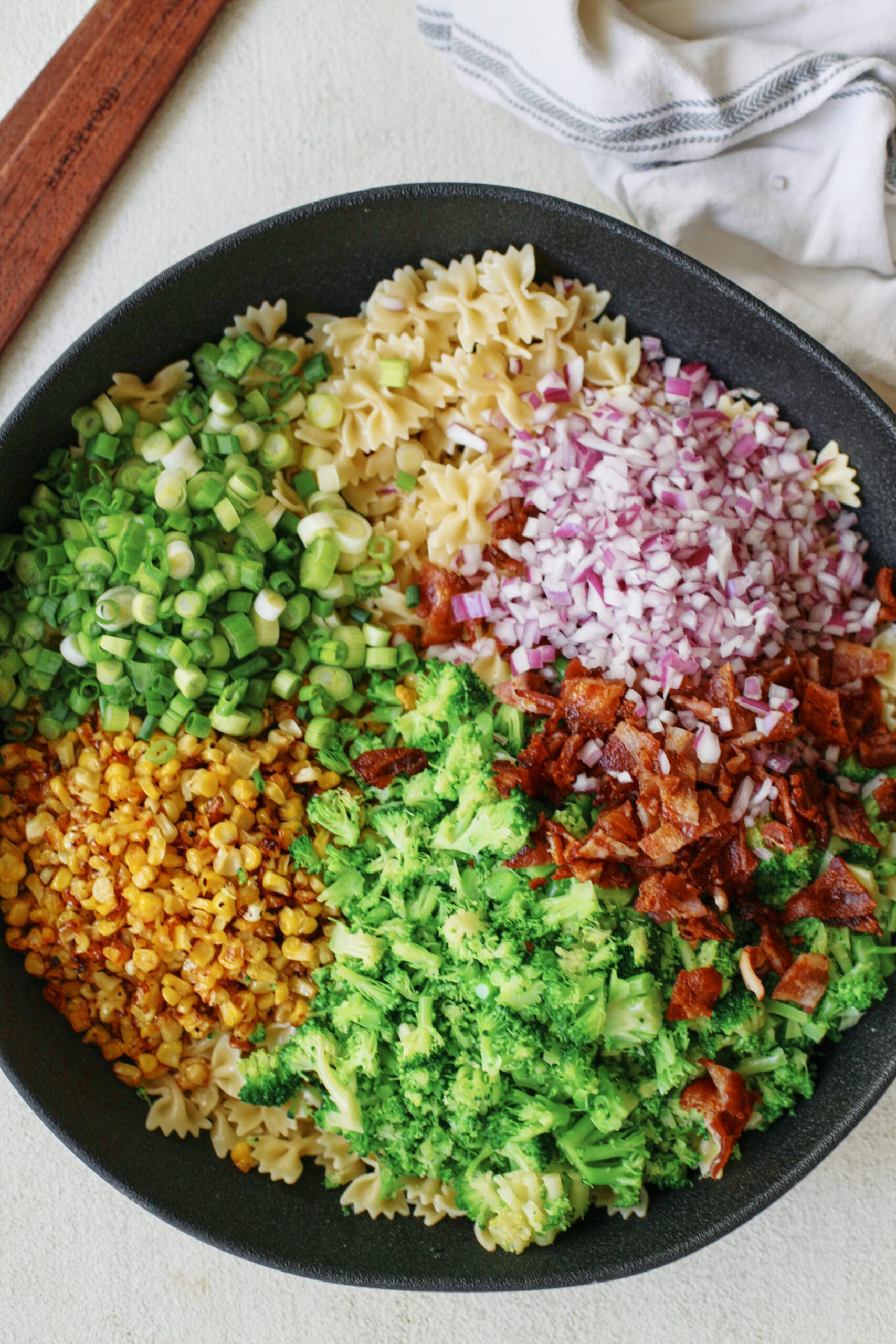roasted corn, bacon, and broccoli salad roasted corn bacon and broccoli pasta salad with green onions, red onion and farfalle
