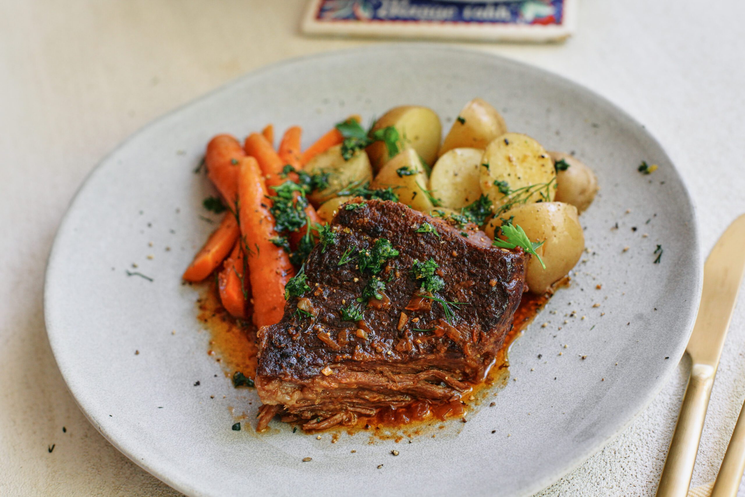 ale braised pot roast plated with baby potatoes and carrots