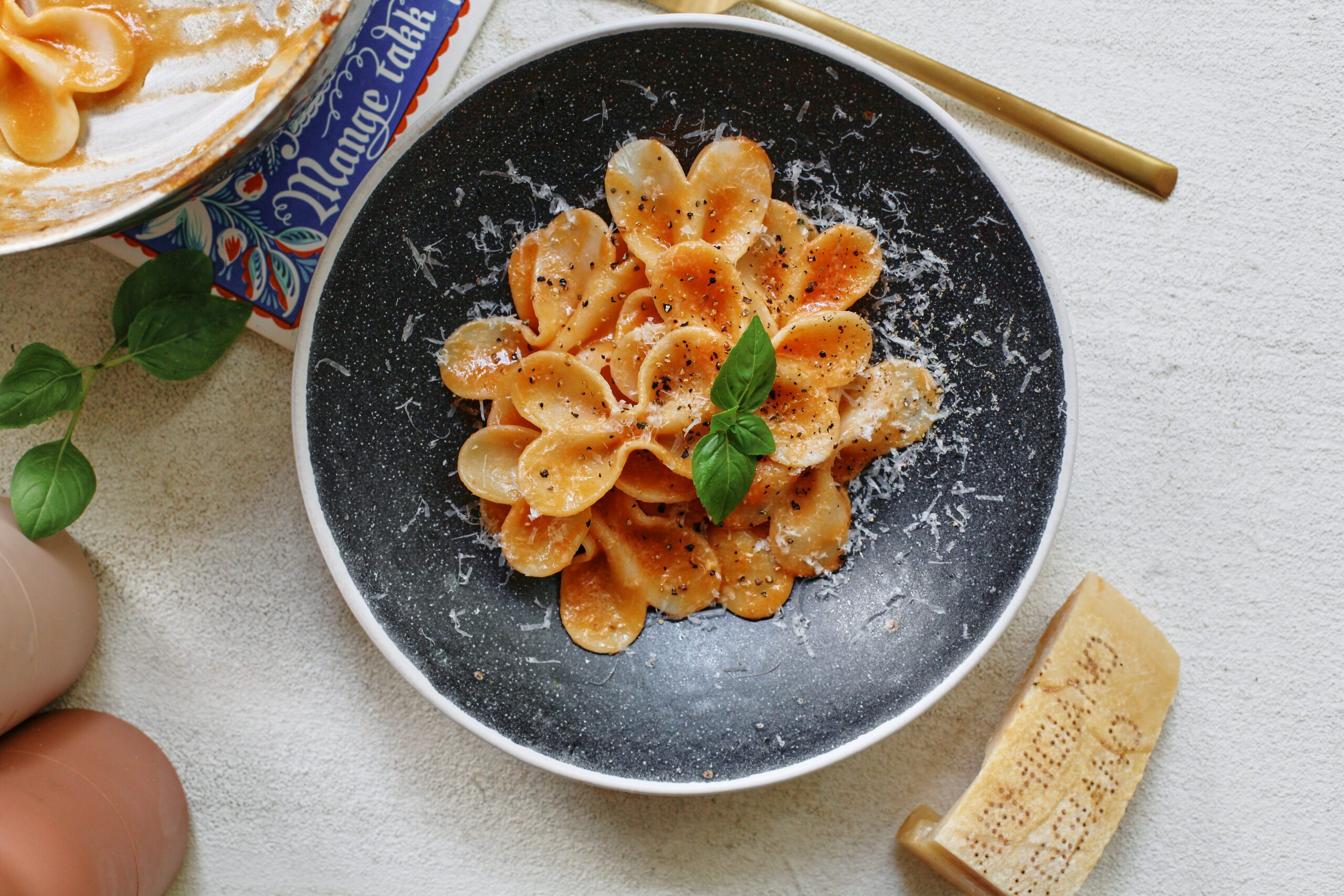 single serve tomato pasta garnished with parmesan and basil