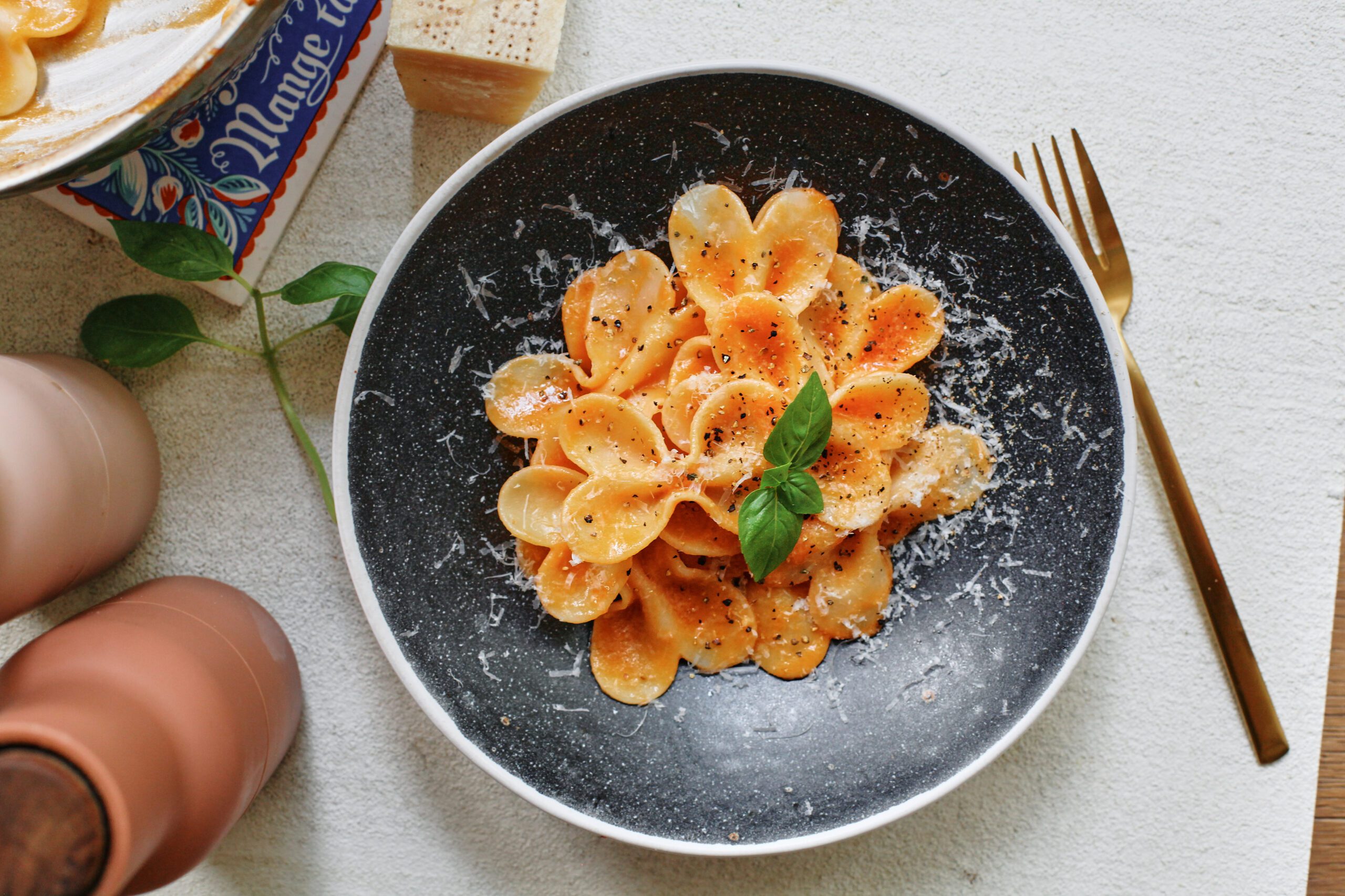 single serve tomato pasta garnished with parmesan and basil