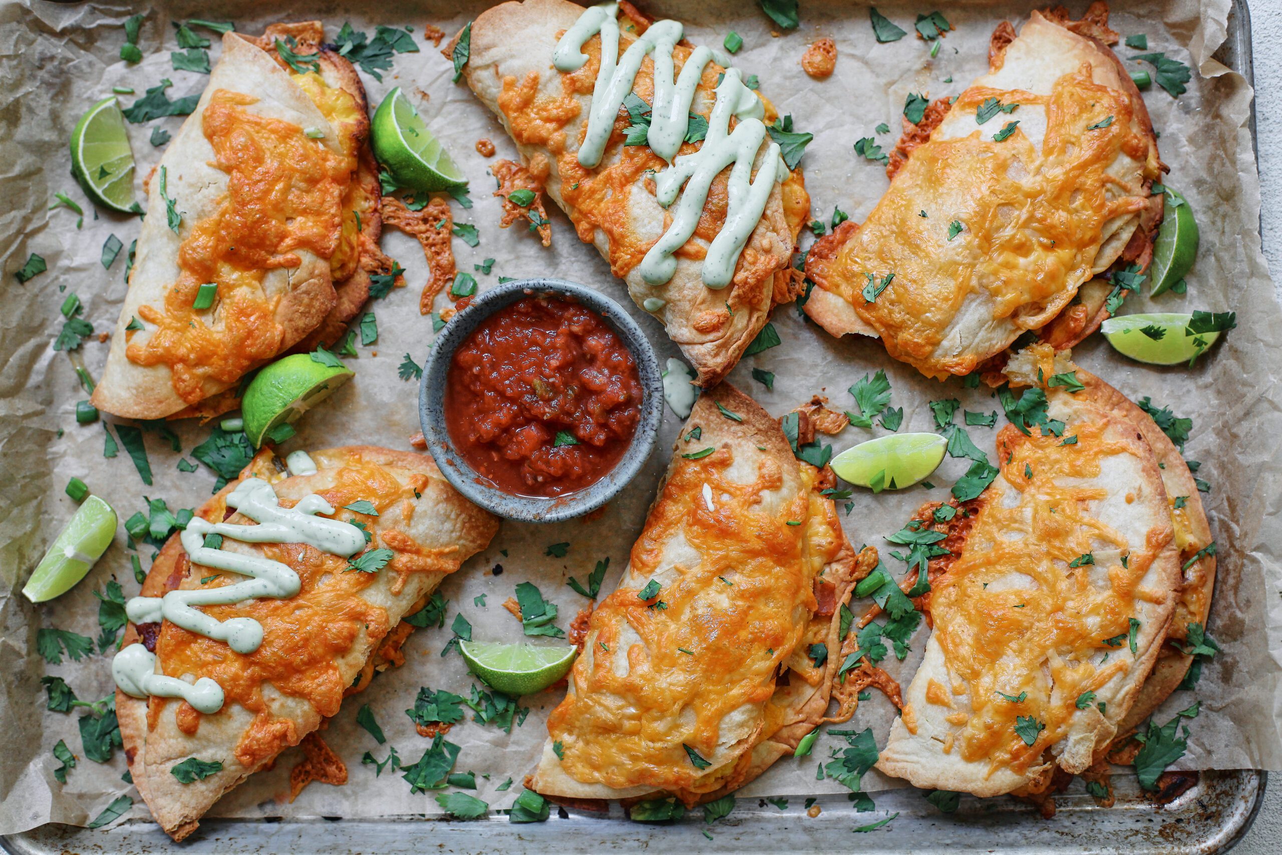 Bacon and Egg Sheet Pan Tacos drizzled with avocado lime crema