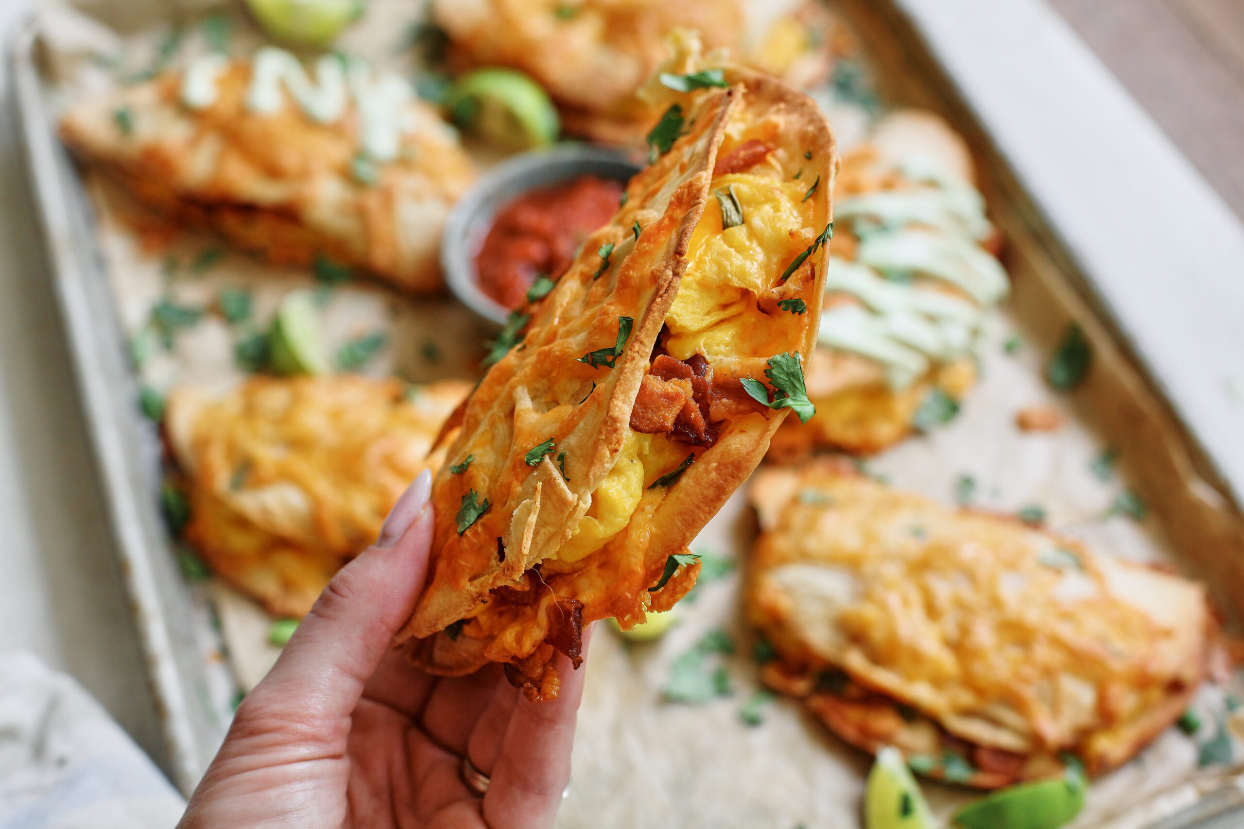 Hand holding a Bacon and Egg Sheet Pan Taco