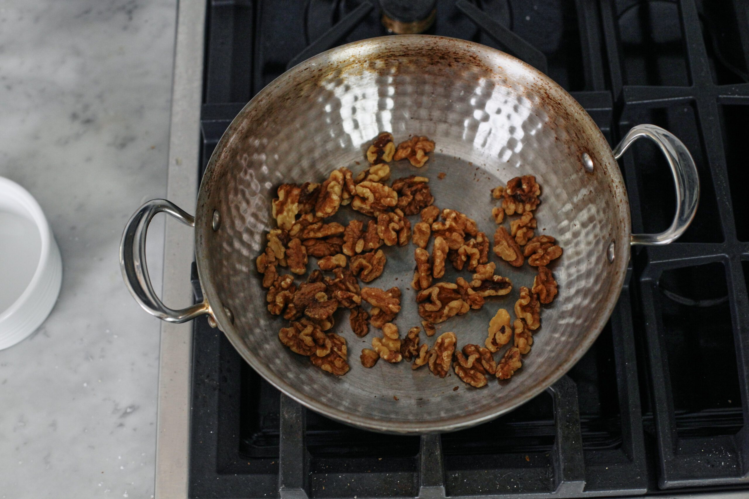 walnuts toasting in a pan on the stove