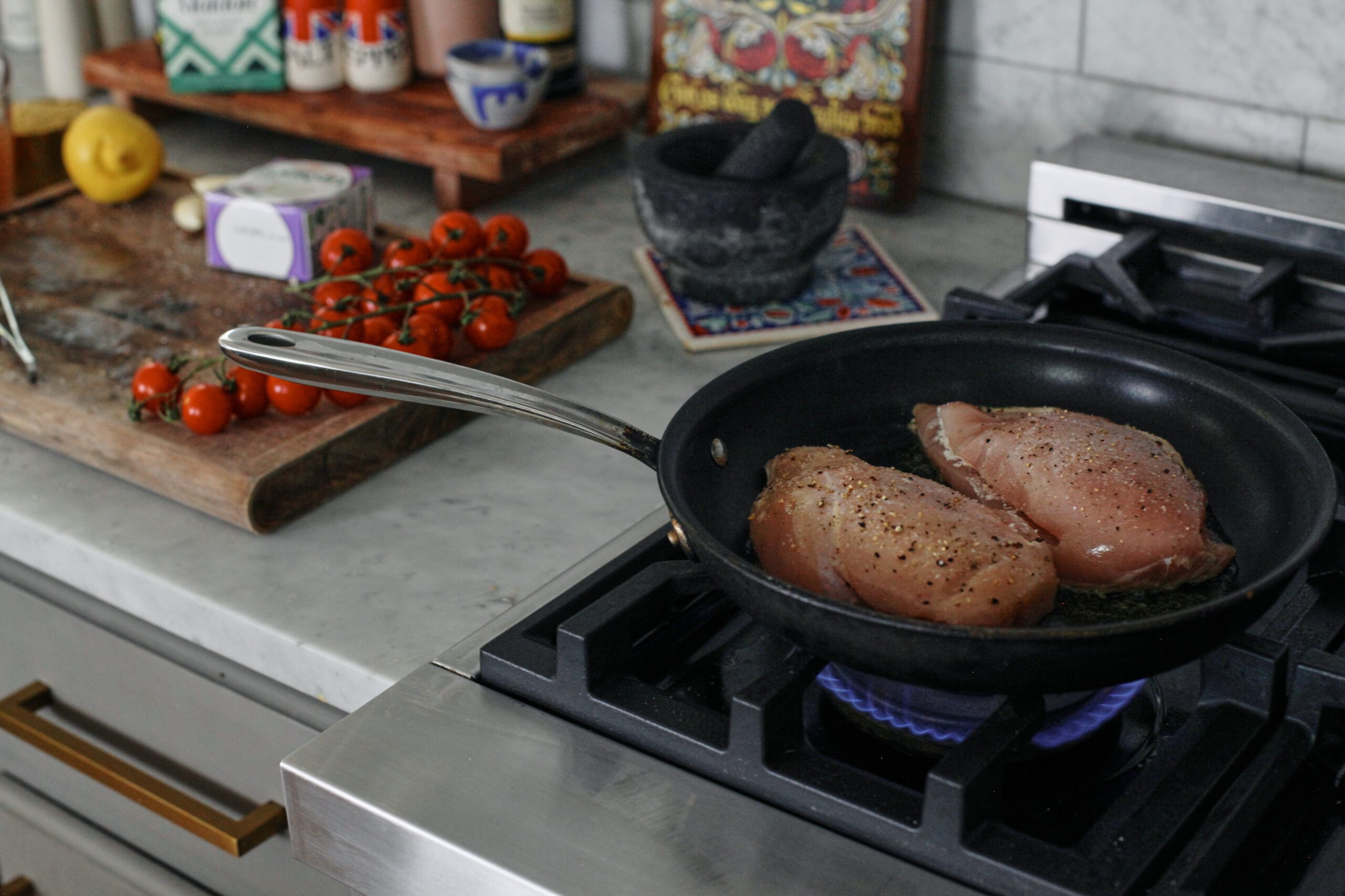 chicken breasts searing in a skillet