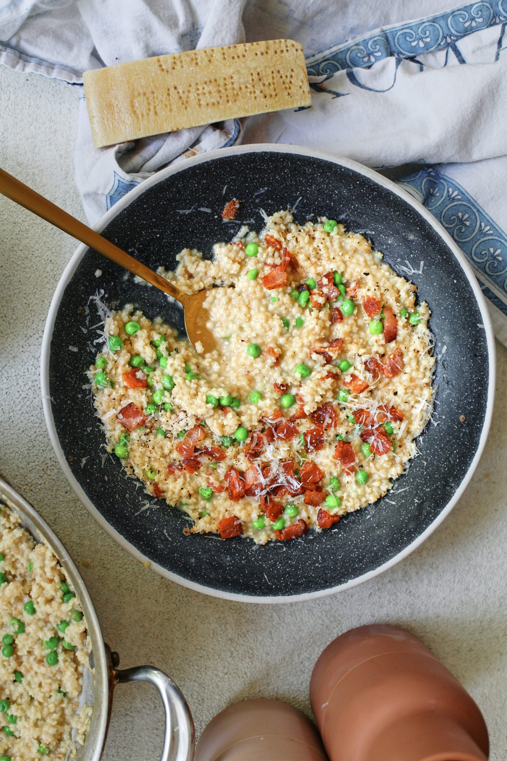cheesy bacon pastina with peas, served in a black bowl