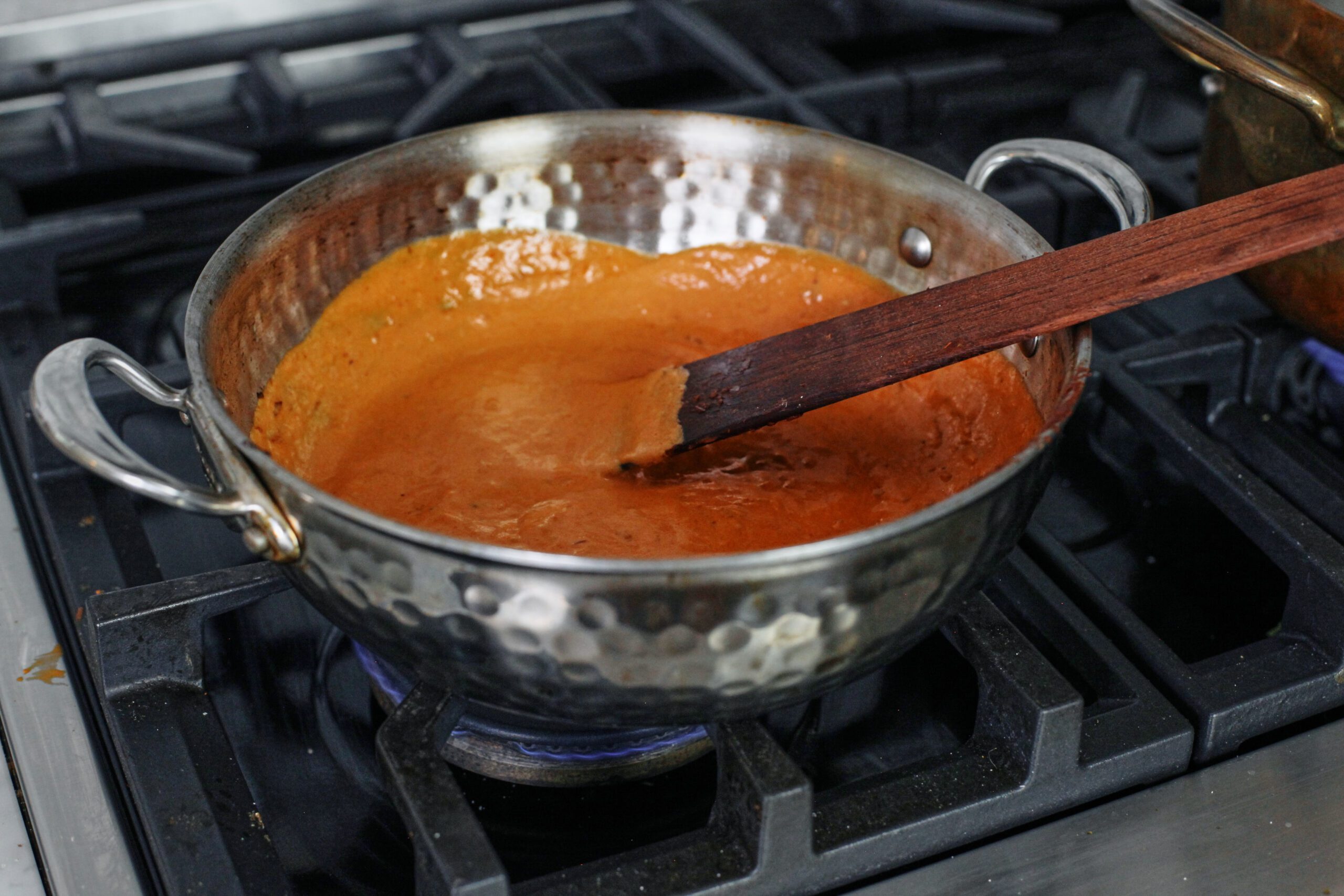 the vodka sauce being cooked in a pan after the heavy cream has been added