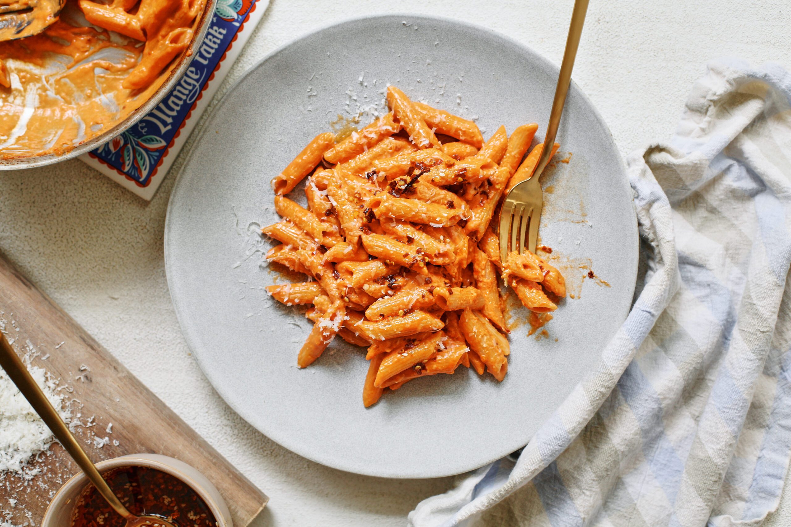 chili oil penne alla vodka on a plate with a gold fork