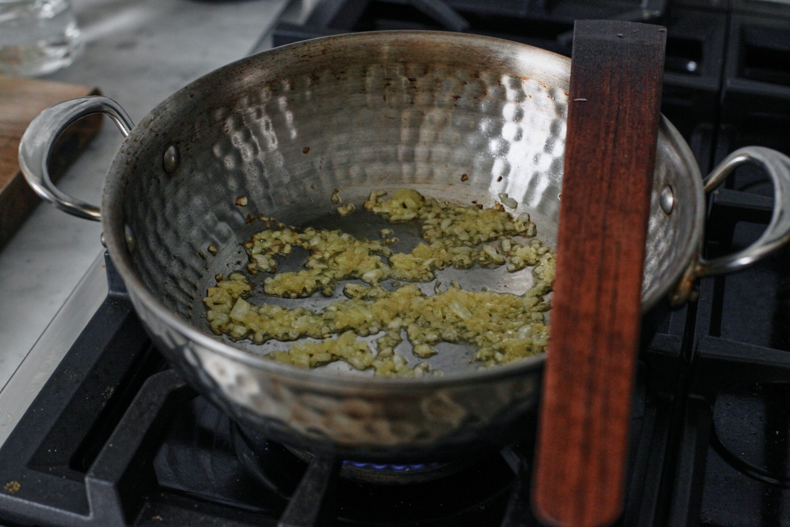 onion being sauteed in a pan on the stove