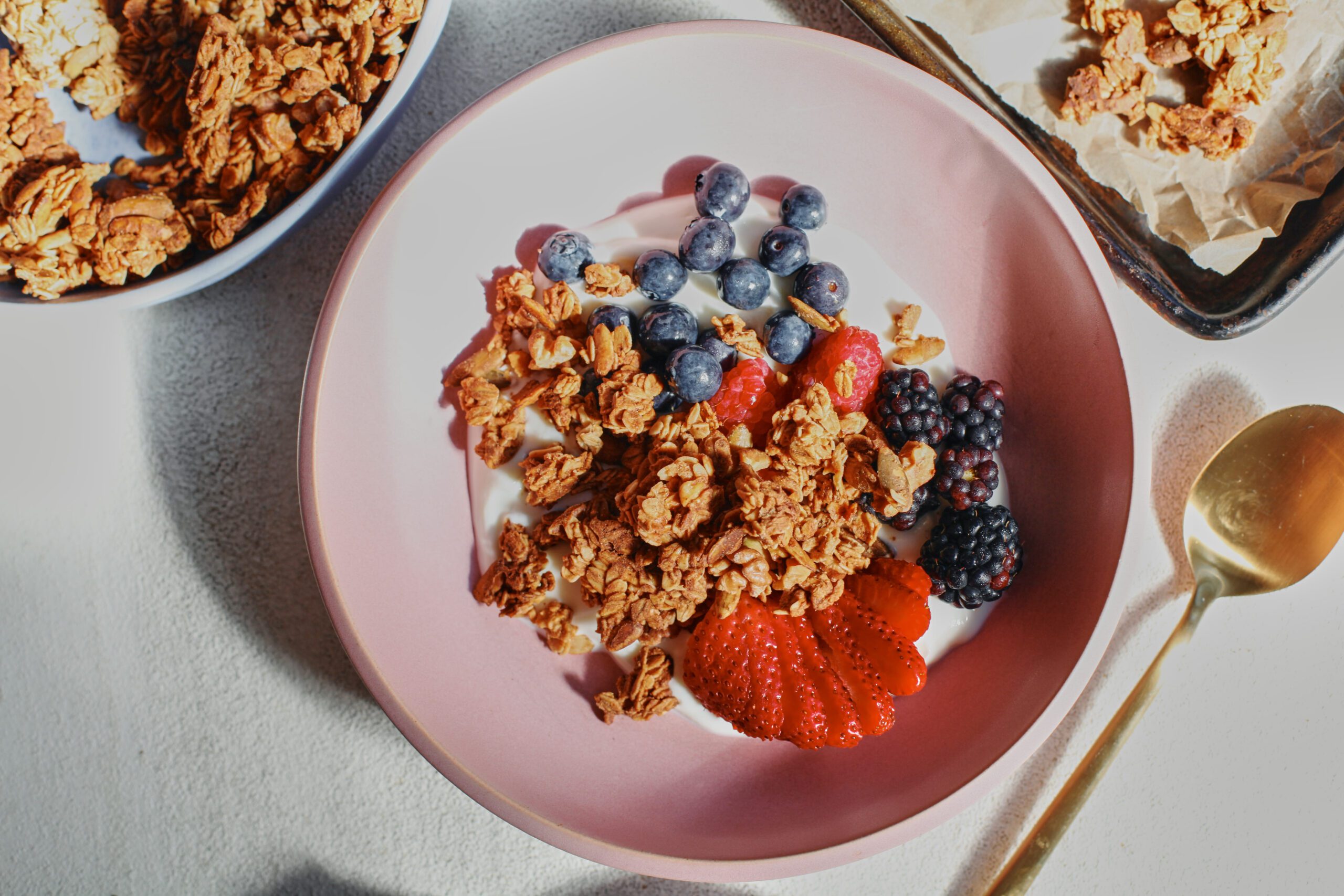 sourdough discard granola in a bowl over yogurt and berries