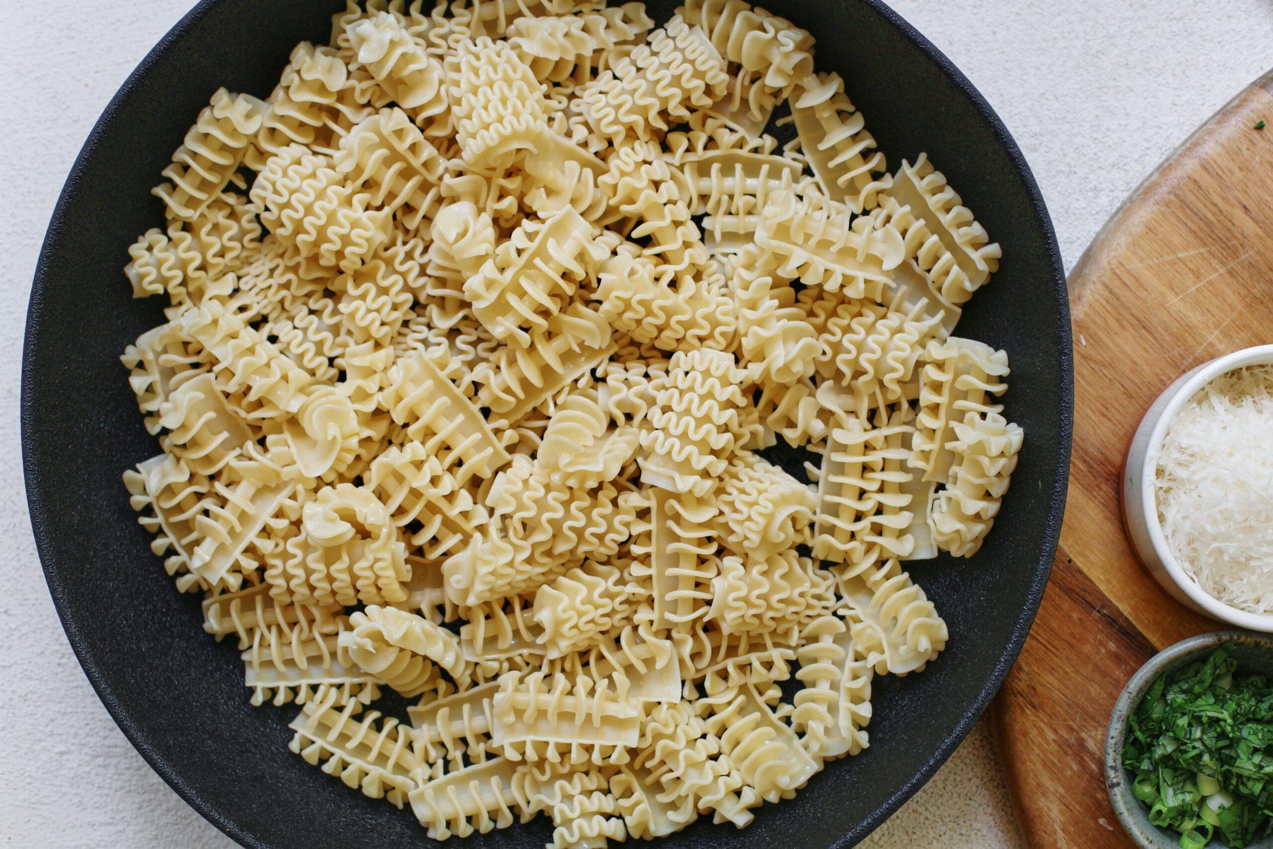 cooked radiatore pasta in a black bowl