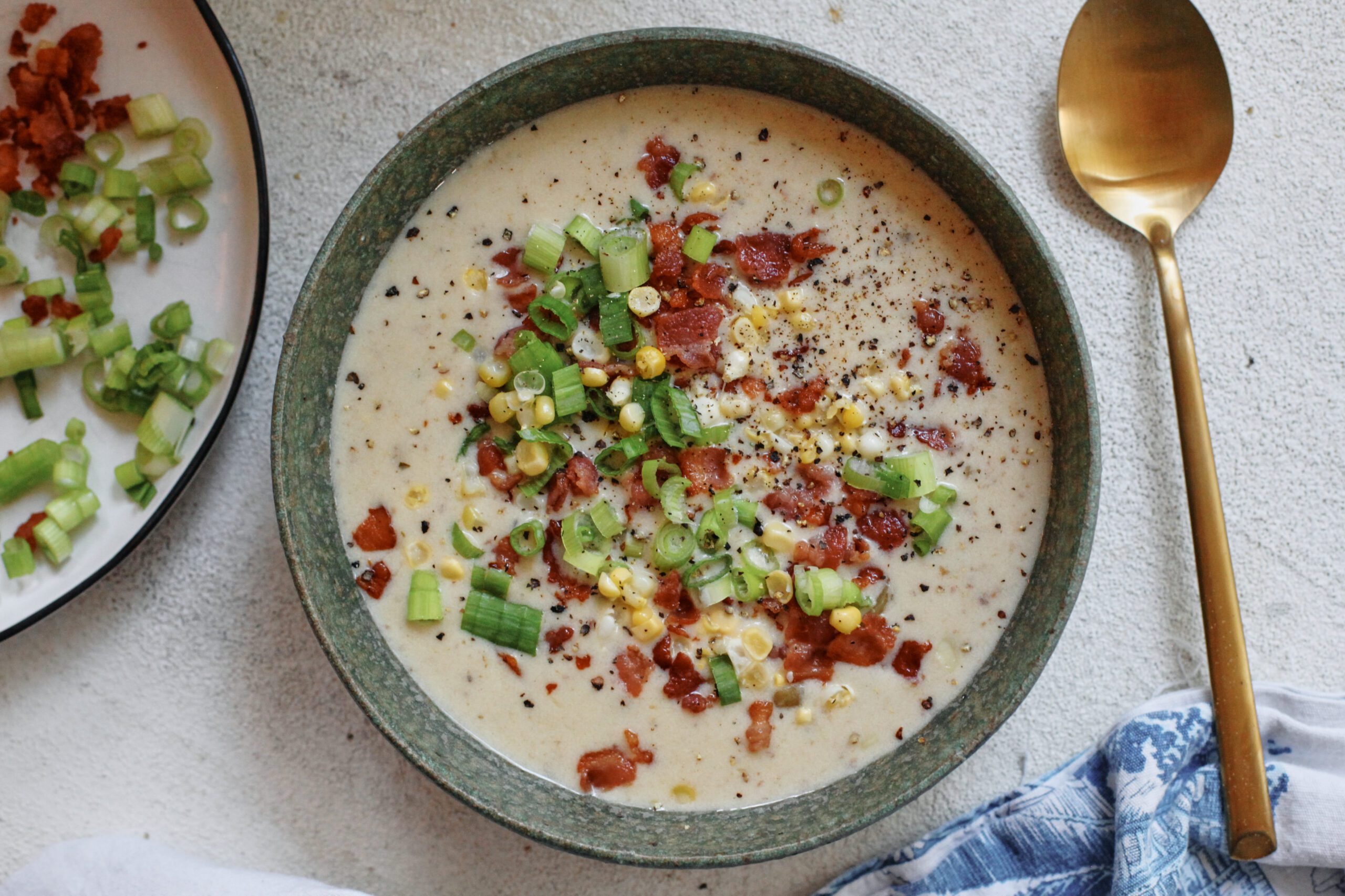 creamy corn chowder topped with green onions, bacon, and black pepper