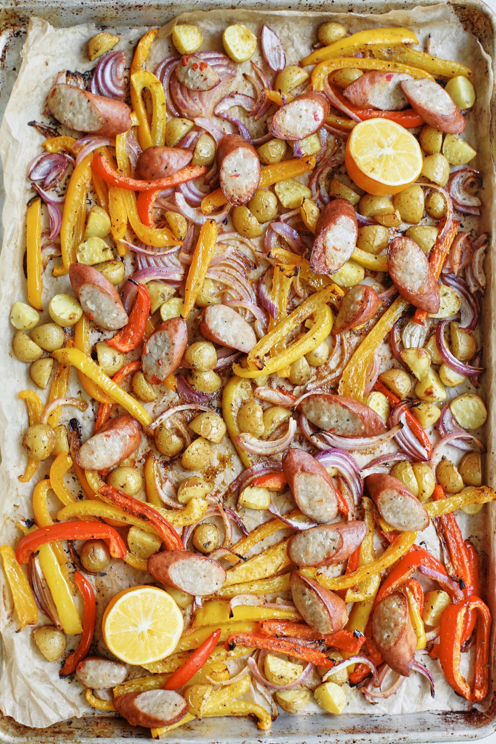 Sheet Pan Sausage, Peppers & Potatoes 5 peppers, potatoes, and onions on a sheet pan after roasting in the oven