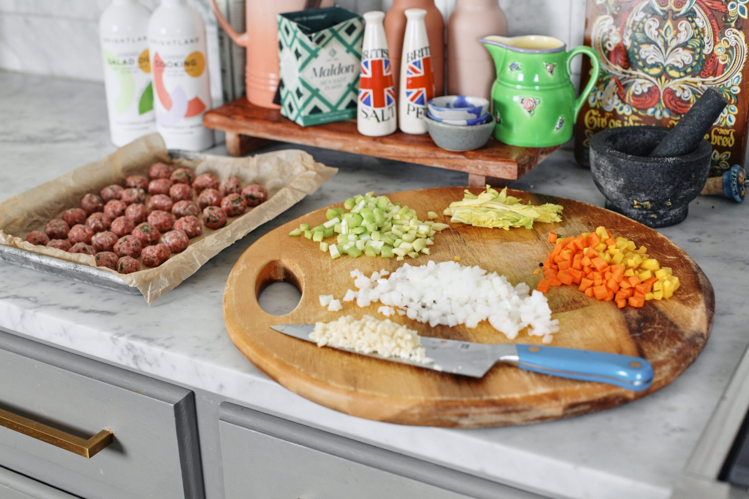 prepped ingredients for italian wedding soup: chopped celery, celery leaves, chopped yellow + orange carrot, chopped onion, minced garlic