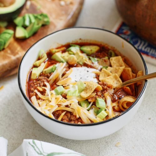 texas style chili topped with sour cream, avocado, green onions, shredded cheese, and fritos