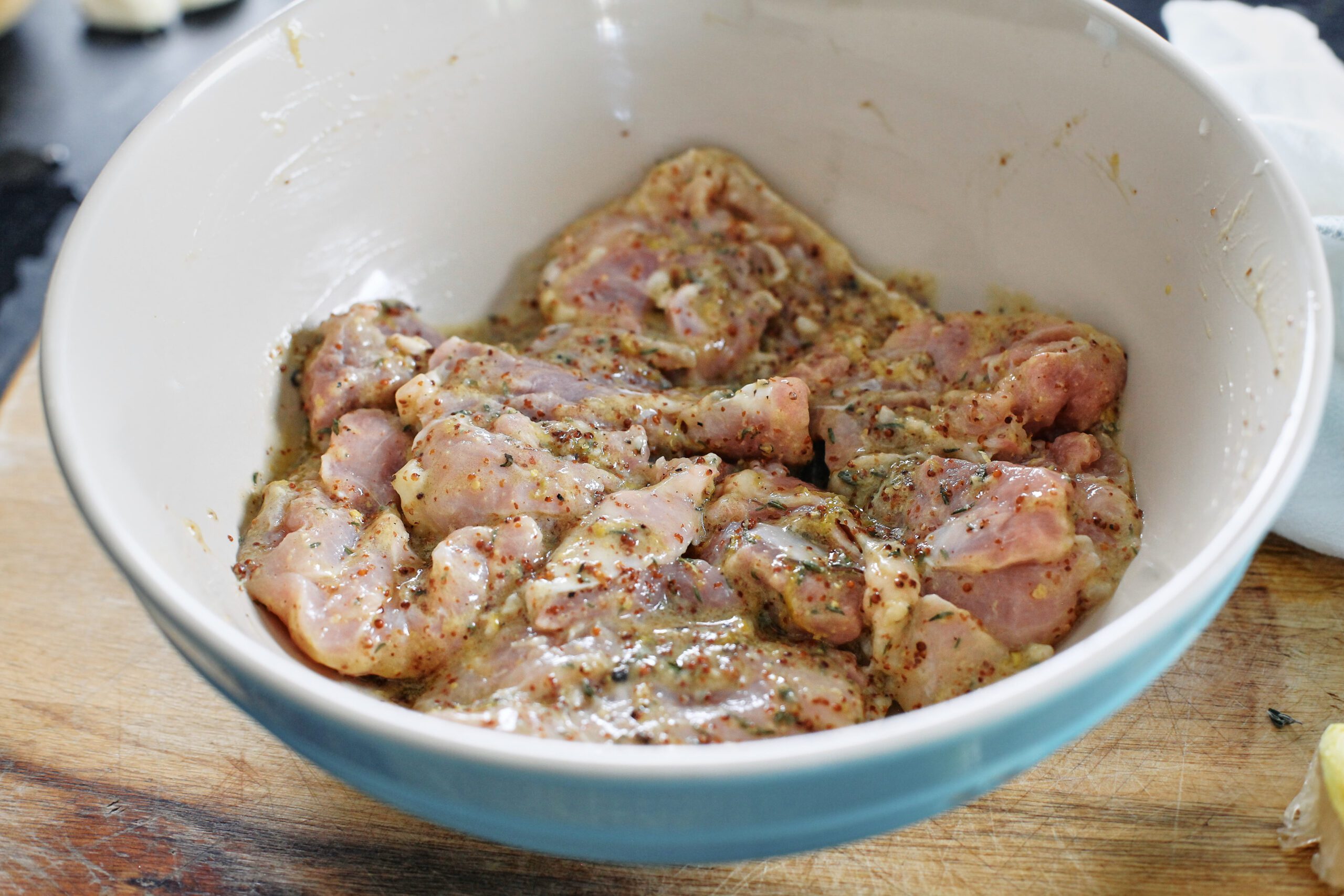 chicken thighs marinating in a large bowl