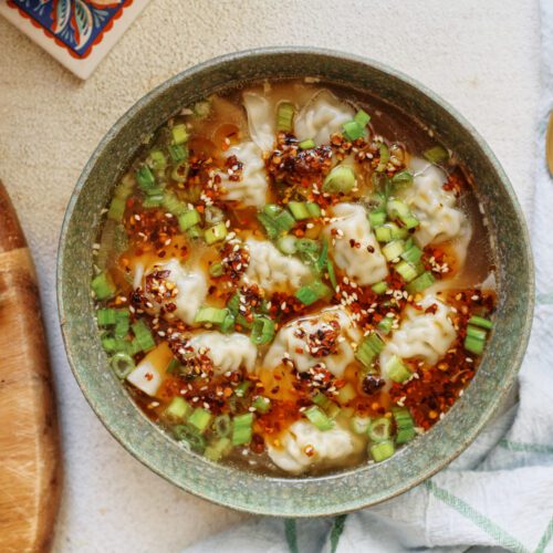 wonton soup topped with green onions and chili oil