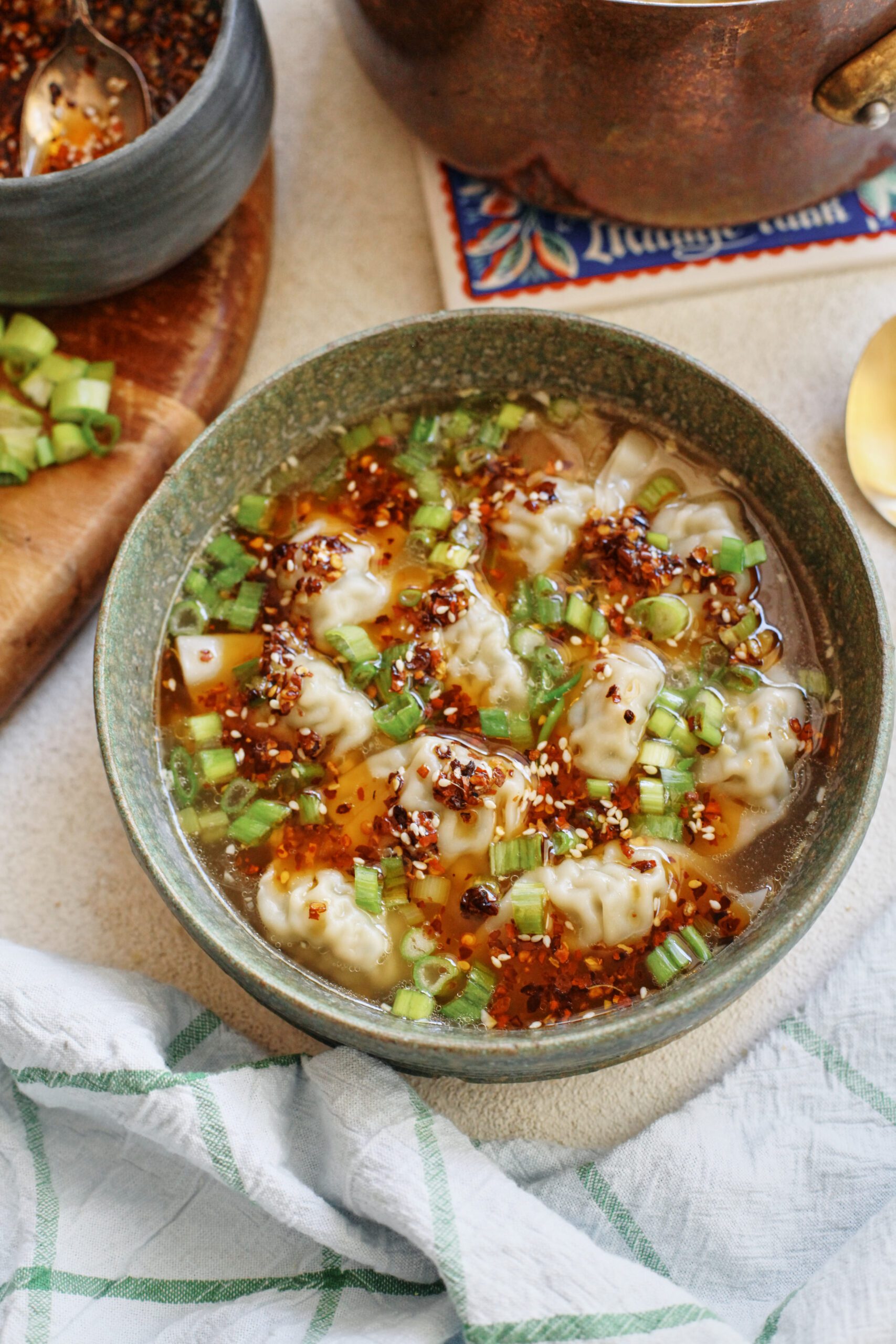 wonton soup topped with green onions and chili oil