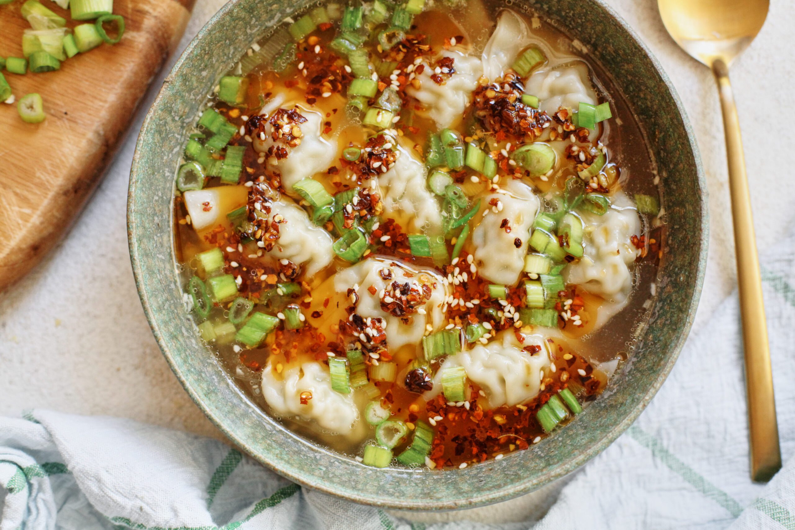 wonton soup topped with green onions and chili oil