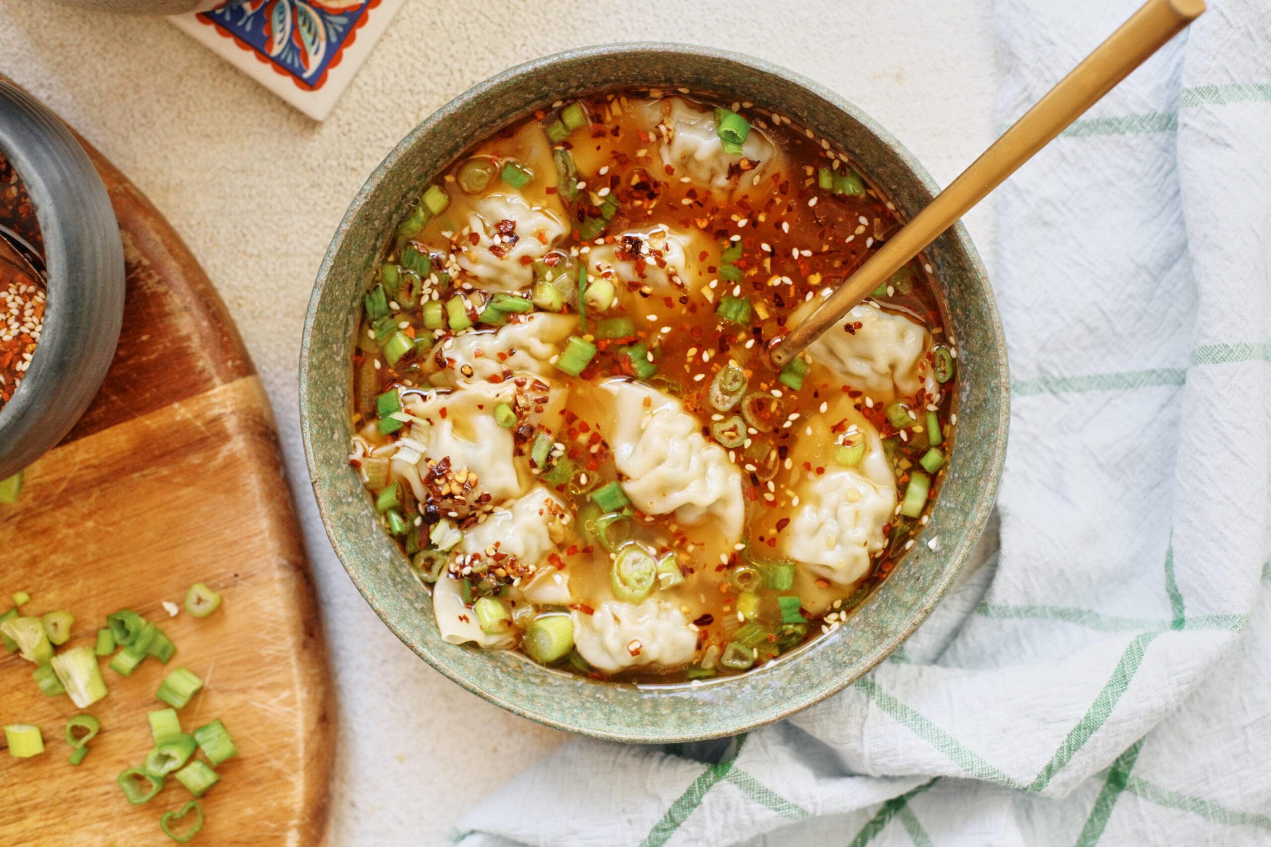 wonton soup topped with green onions and chili oil