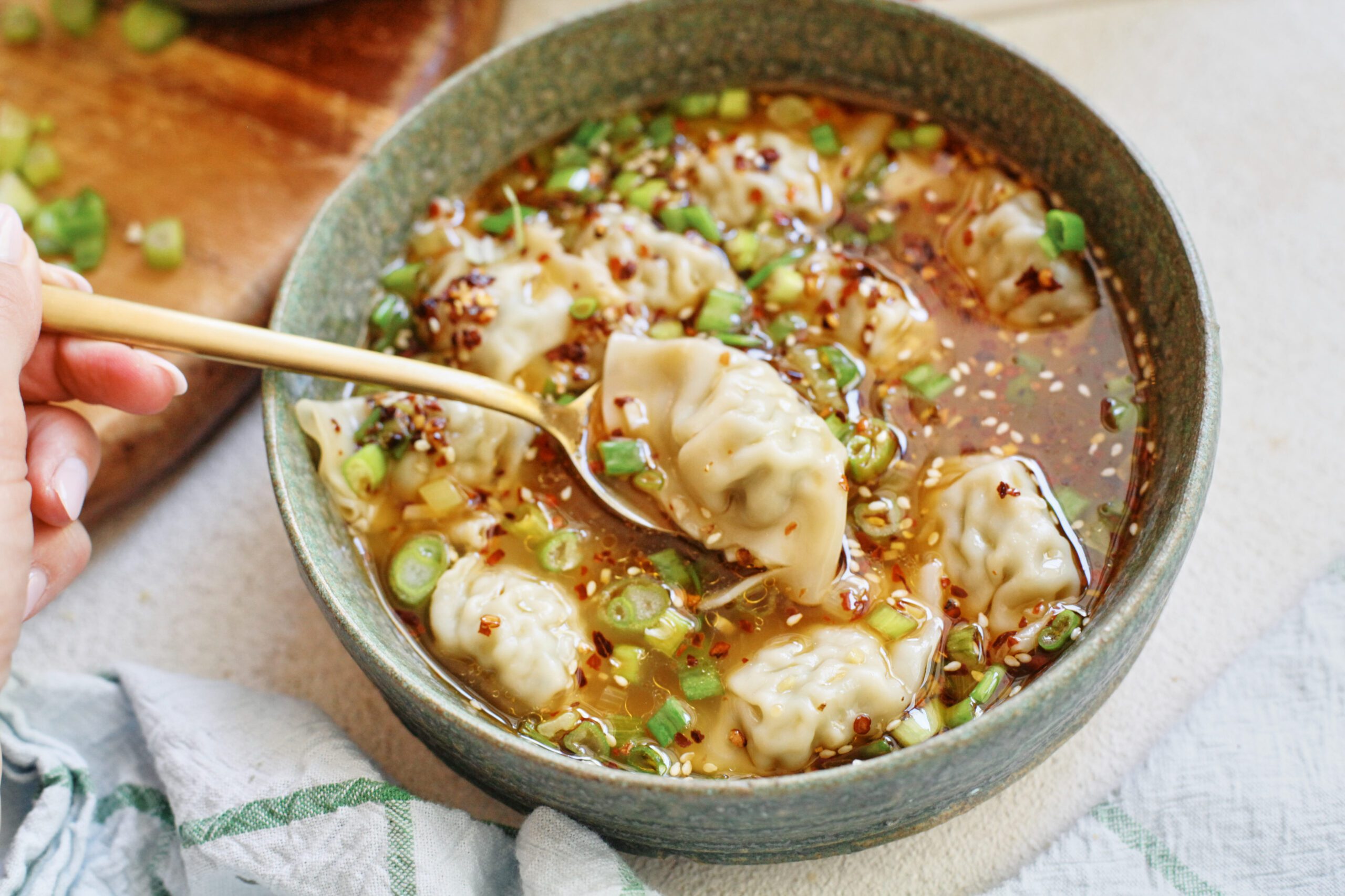 wonton soup topped with green onions and chili oil