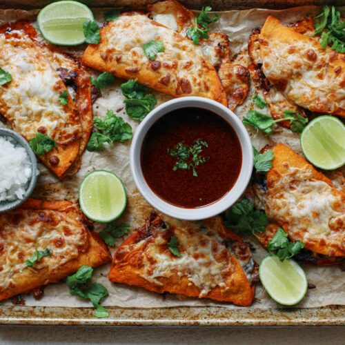 birria sheet pan tacos + a bowl of consomme dressed with cilantro, lime wedges, and a bowl of chopped white onions