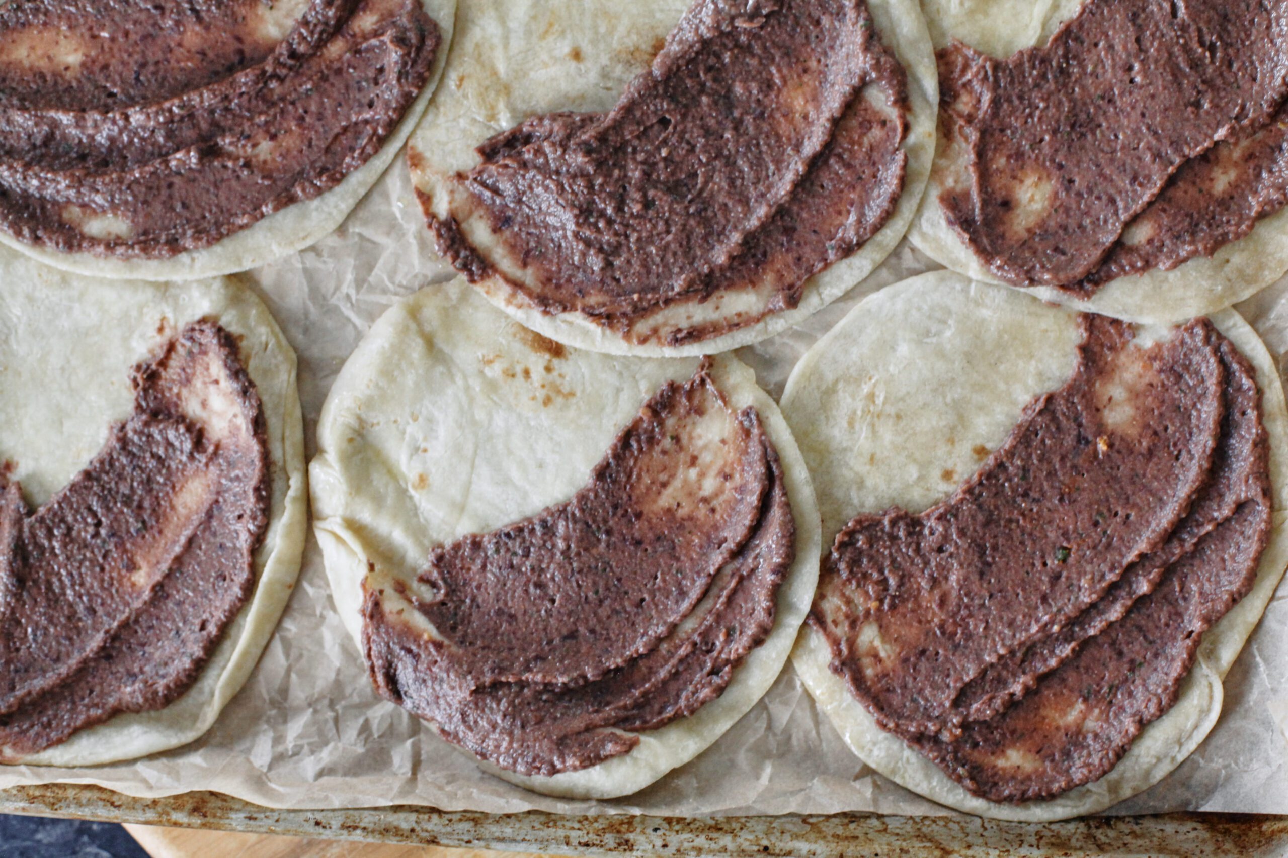 black bean puree spread on six tortillas